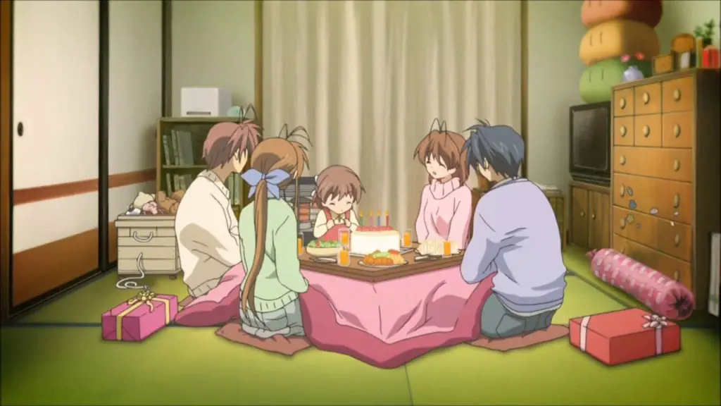 Nagisa, Tomoya and their family celebrating Ushio's birthday sat around a table with a birthday cake