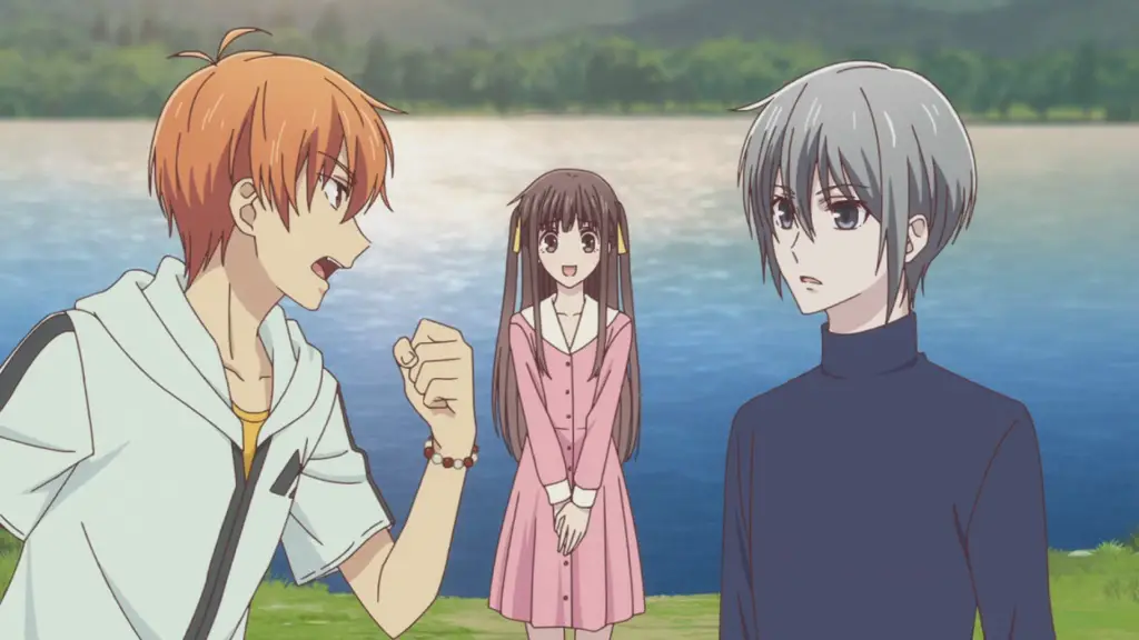 two boys argue in front of a girl and a lake